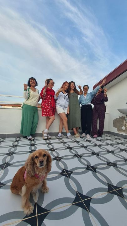 Terasta köpekle birlikte grup fotoğrafı