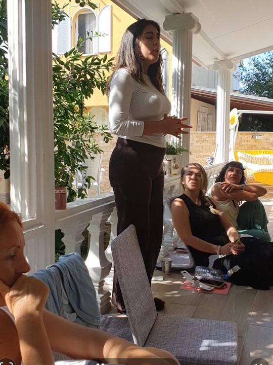 Sütunlu terasta dinleyen katılımcılar